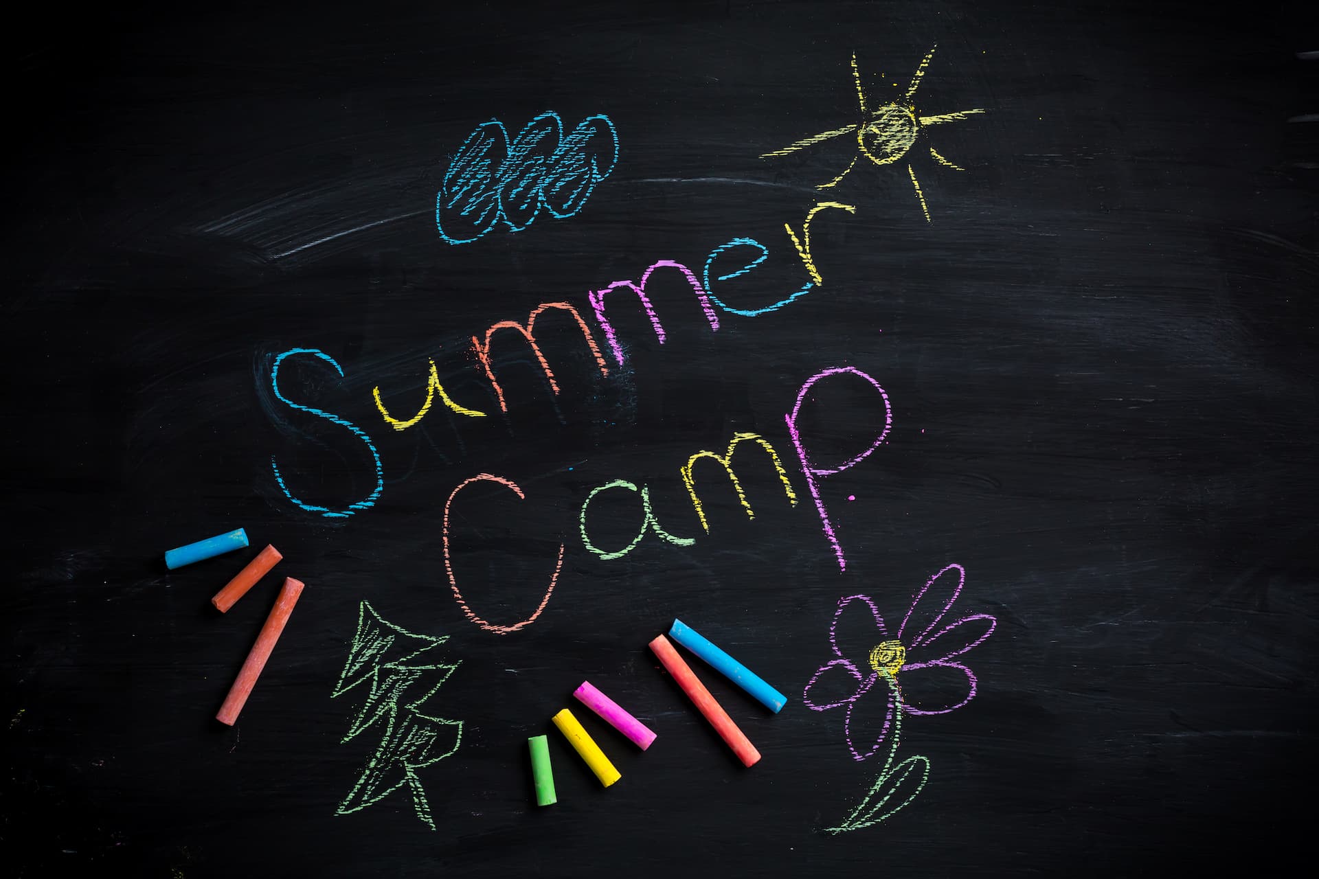 Colorful summer camp chalk drawing on blackboard