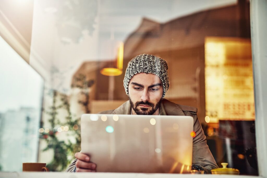 Man learning from laptop in a cafe